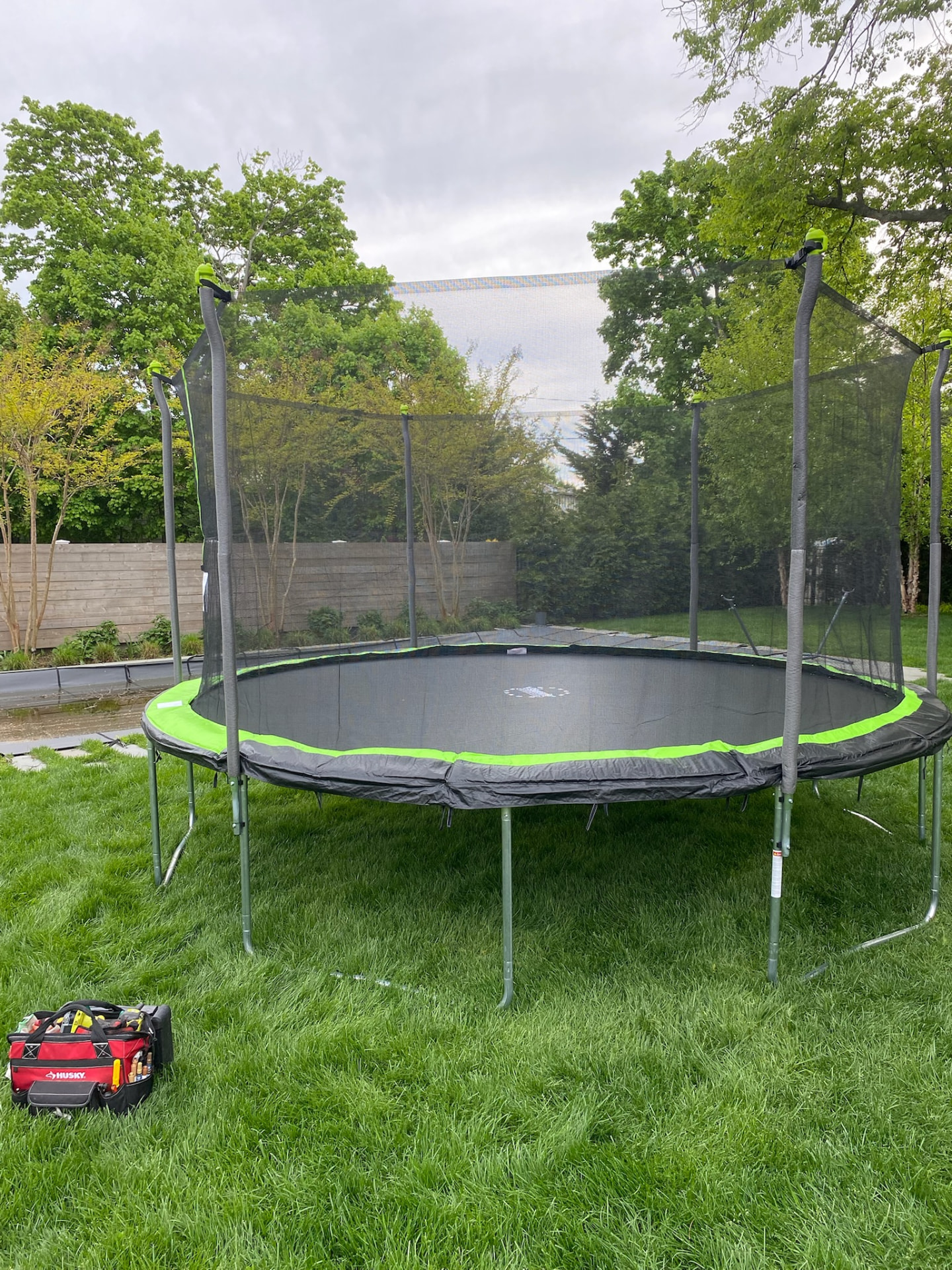Assembled backyard trampoline with safety net enclosure on a lawn