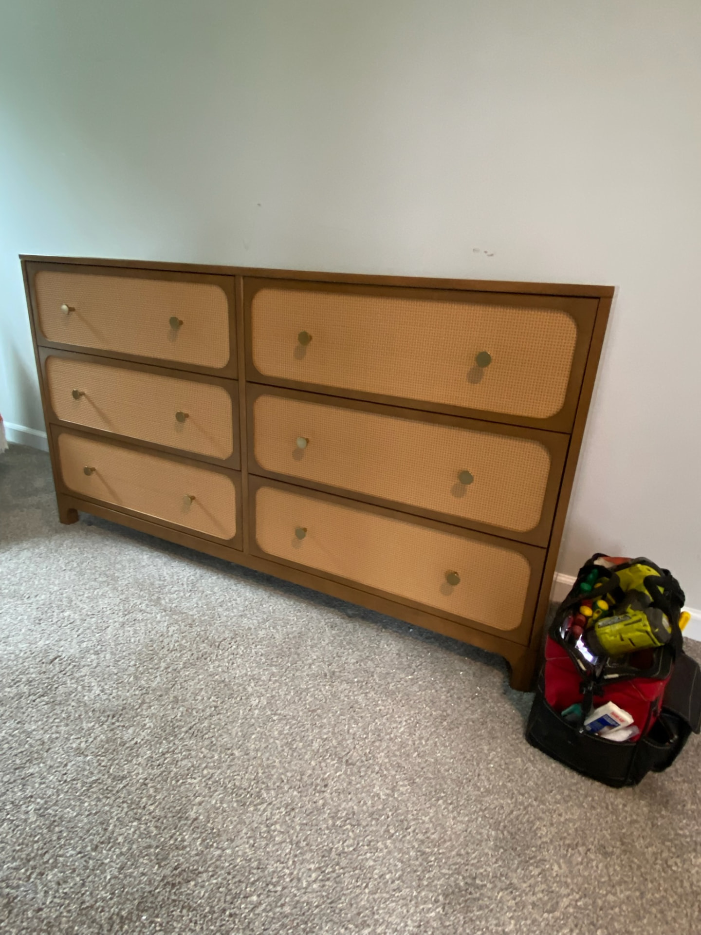 Assembled wooden dresser with cane drawer fronts and brass knobs