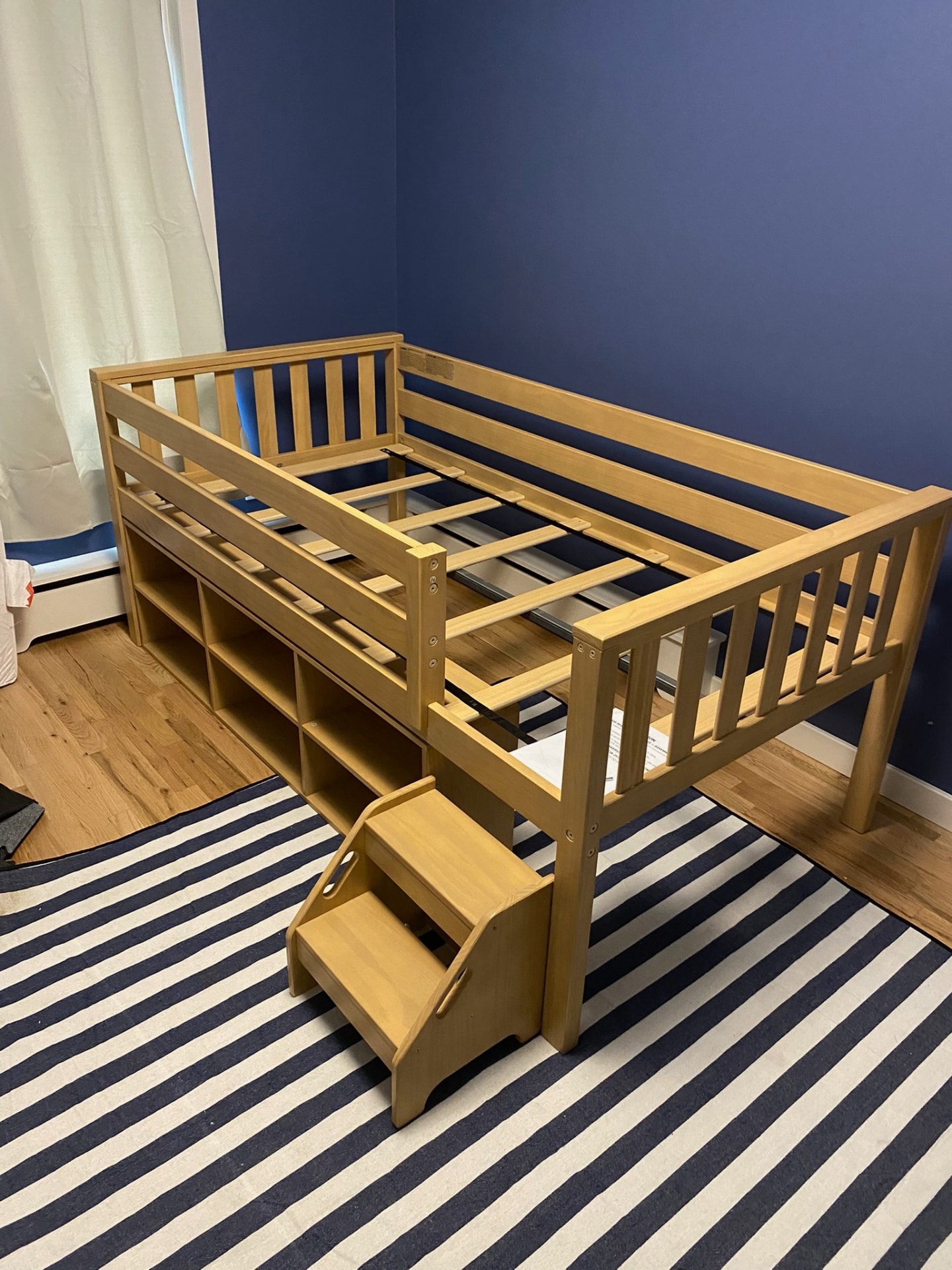 Completed wooden loft bed with storage shelves and steps assembled by Alex