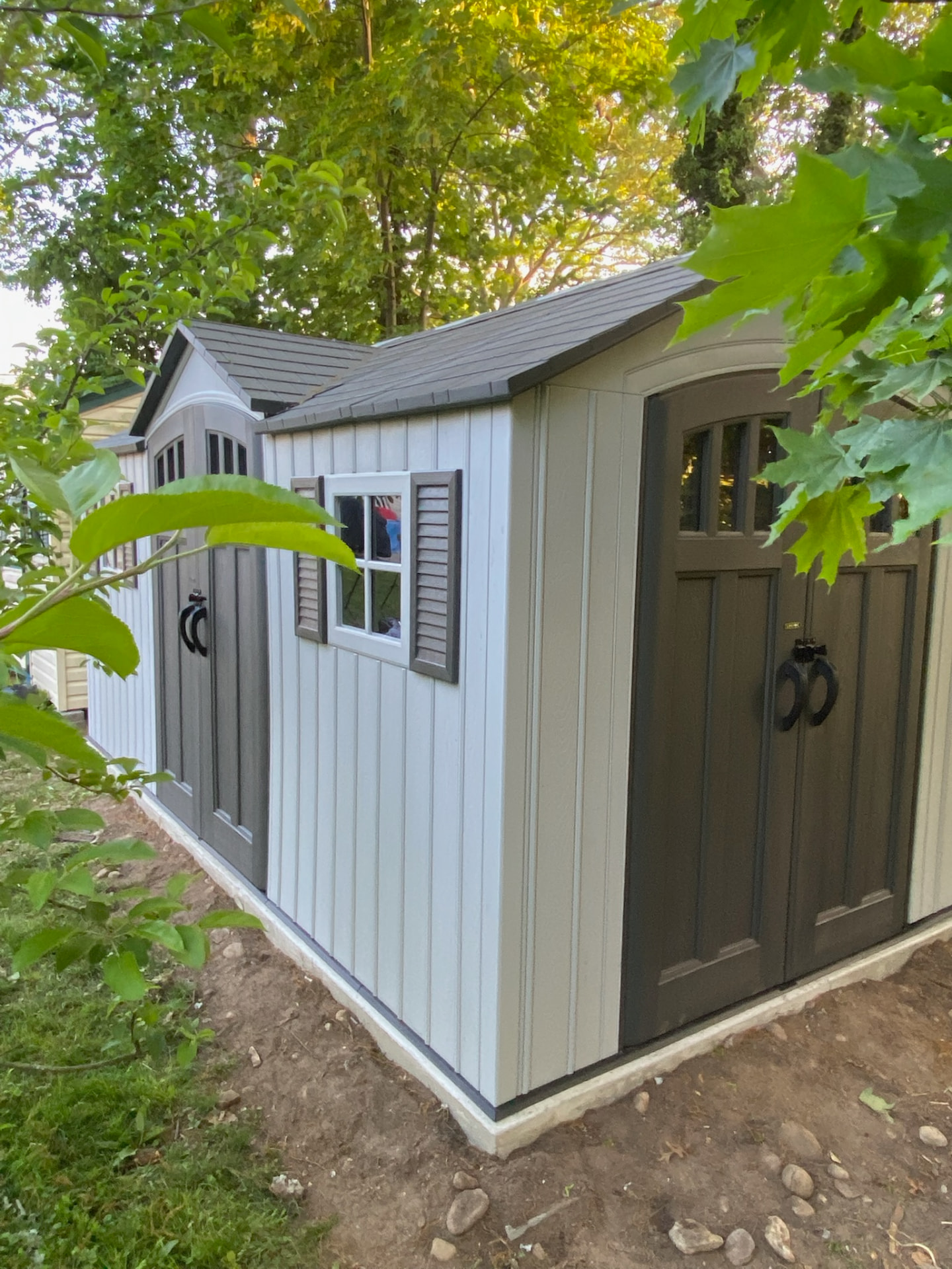 Completed resin backyard storage shed with double doors and window
