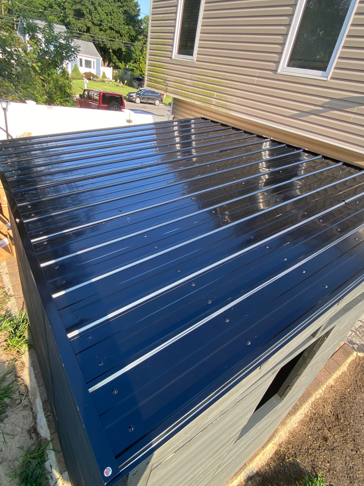 Completed dark metal roof installed on an outdoor shed