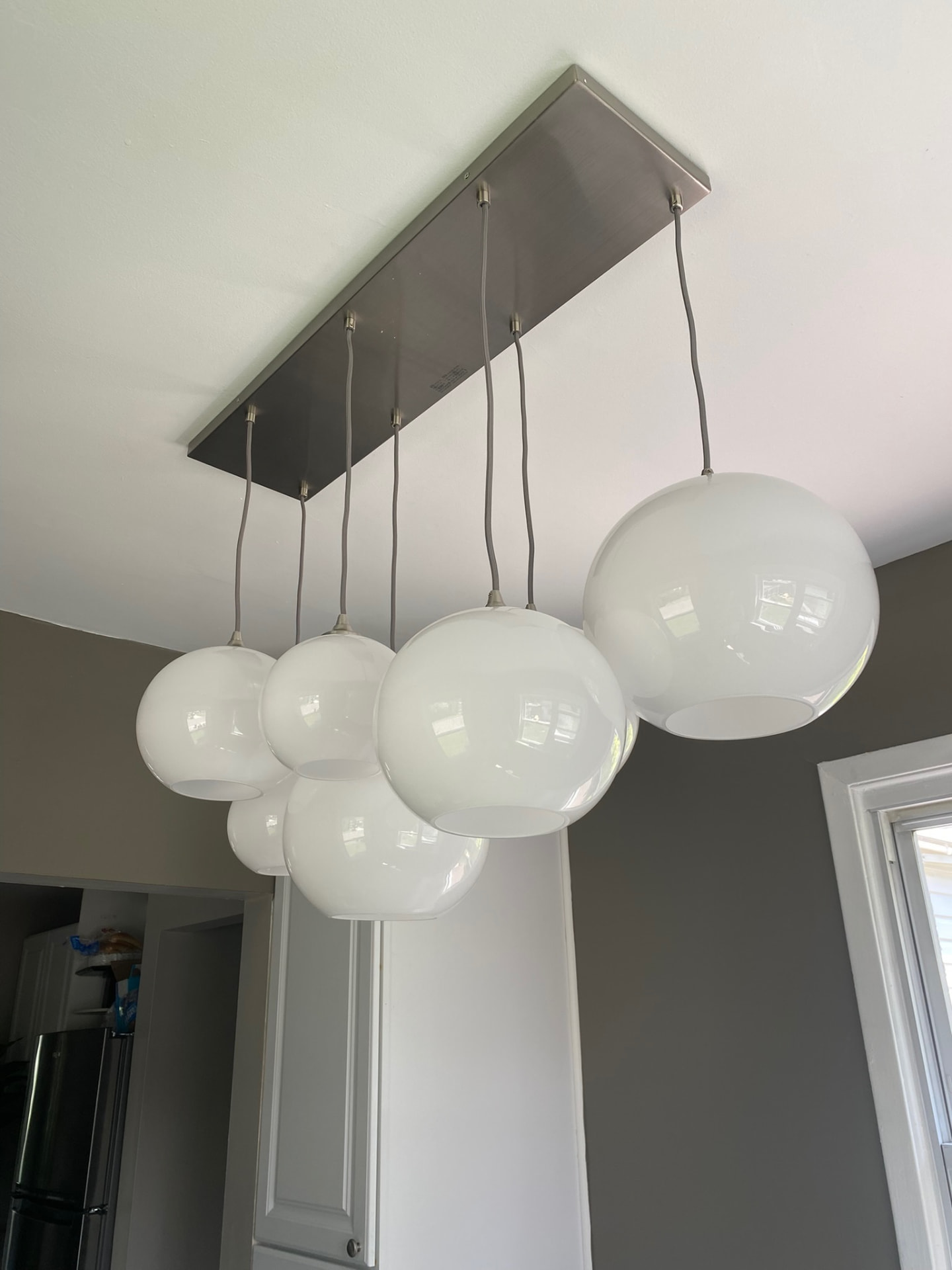Modern multi-globe pendant light fixture installed over a kitchen area