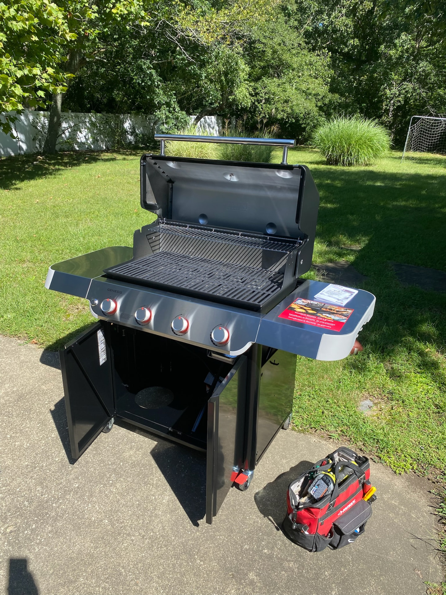 Completed four-burner gas grill assembled outdoors